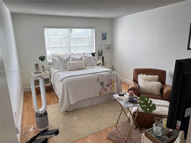 bedroom featuring a textured ceiling and light hardwood / wood-style floors