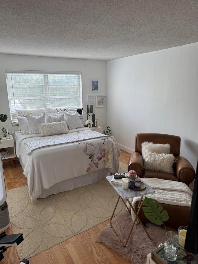 bedroom with a textured ceiling and light wood-type flooring