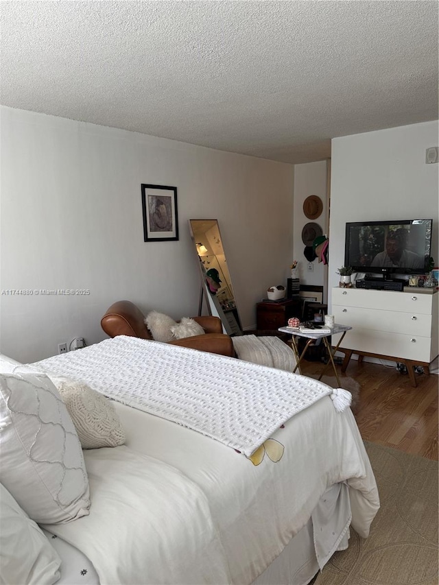 bedroom featuring wood-type flooring and a textured ceiling