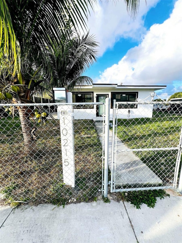 view of gate with a yard and a fenced front yard