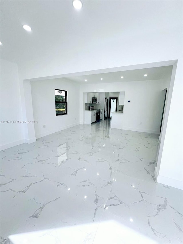 unfurnished living room featuring recessed lighting, marble finish floor, and baseboards