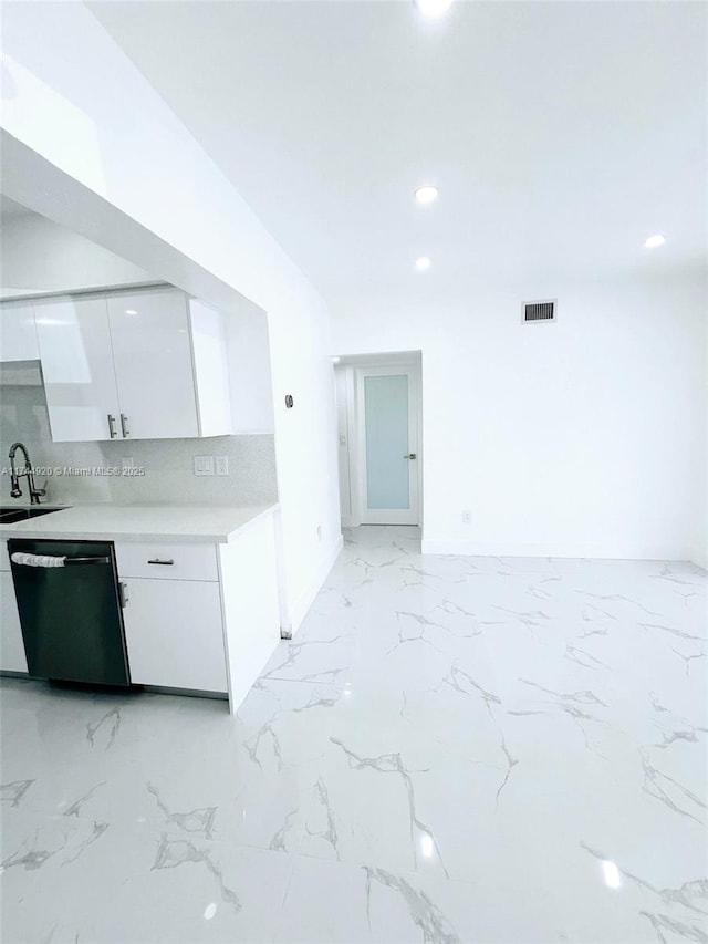 kitchen featuring black dishwasher, marble finish floor, light countertops, decorative backsplash, and white cabinetry