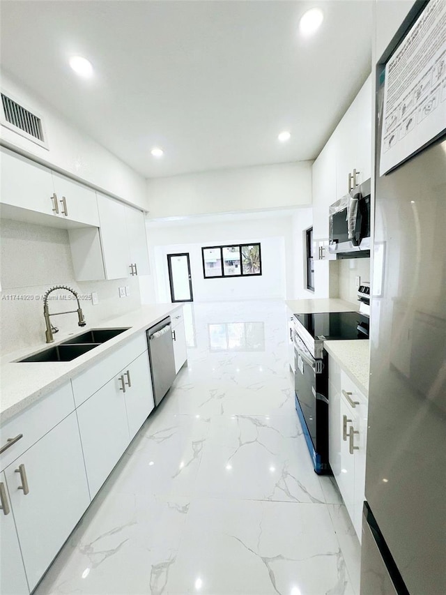 kitchen with visible vents, white cabinets, appliances with stainless steel finishes, marble finish floor, and a sink