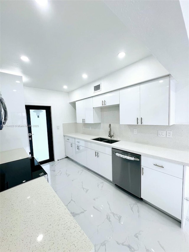 kitchen with a sink, white cabinetry, light countertops, and stainless steel dishwasher