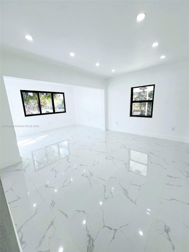 unfurnished room featuring marble finish floor, baseboards, and recessed lighting