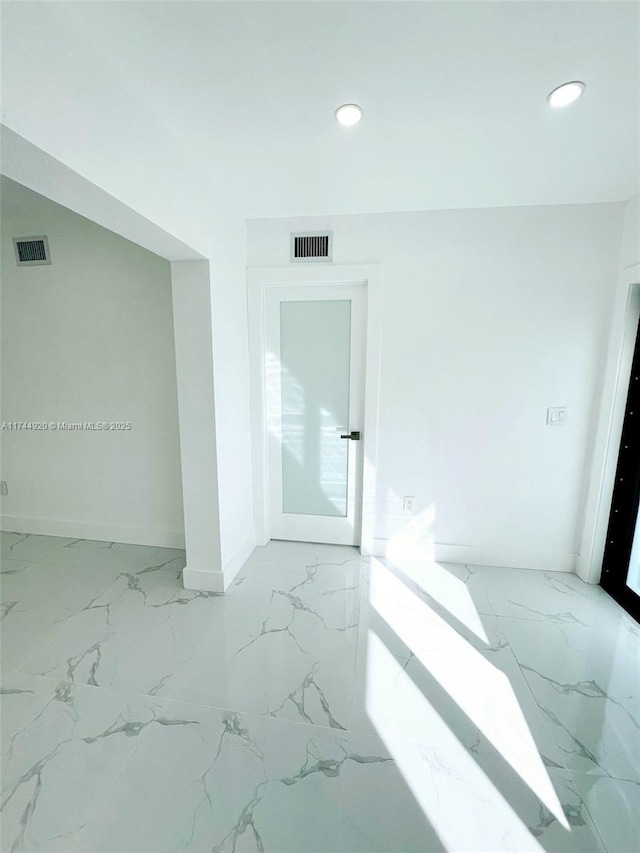 unfurnished room with recessed lighting, marble finish floor, and visible vents