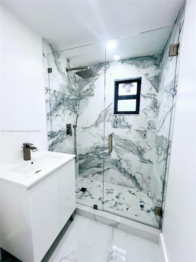 bathroom with marble finish floor, a marble finish shower, and vanity