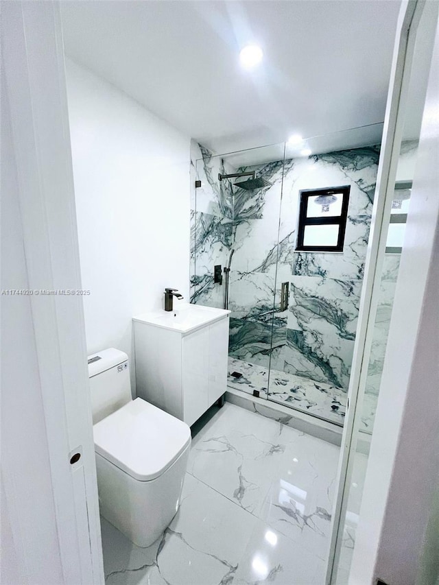 full bath with toilet, marble finish floor, a marble finish shower, and vanity