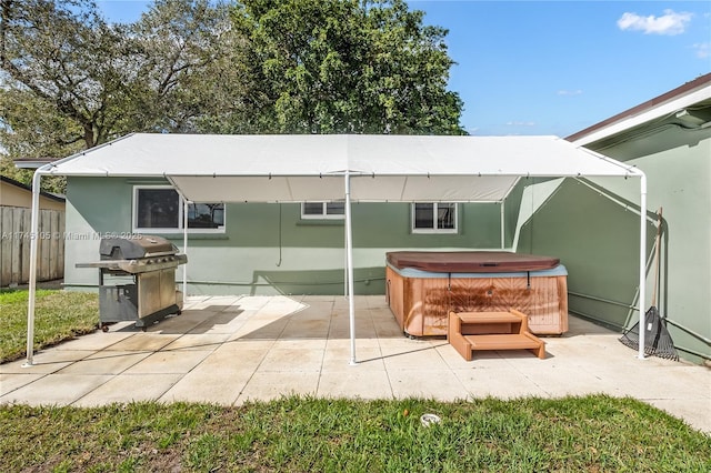 back of house featuring a hot tub and a patio