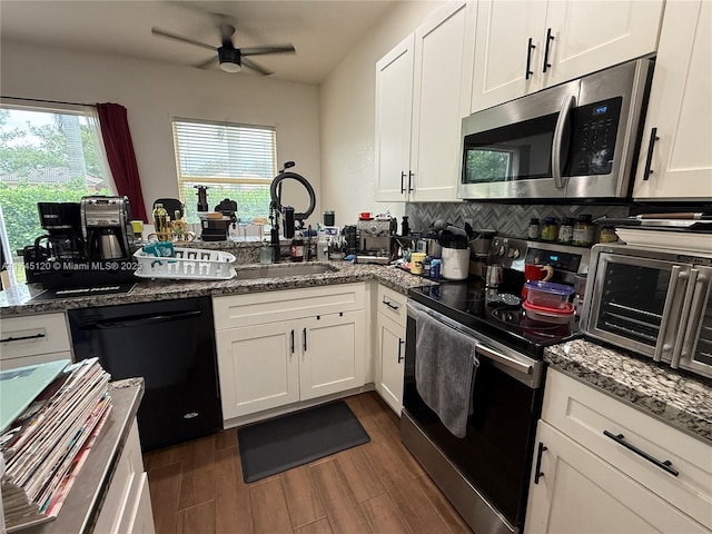 kitchen featuring black appliances, a sink, white cabinetry, a peninsula, and dark wood-style flooring