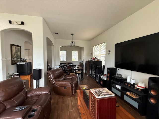 living room featuring wood finish floors, visible vents, and arched walkways