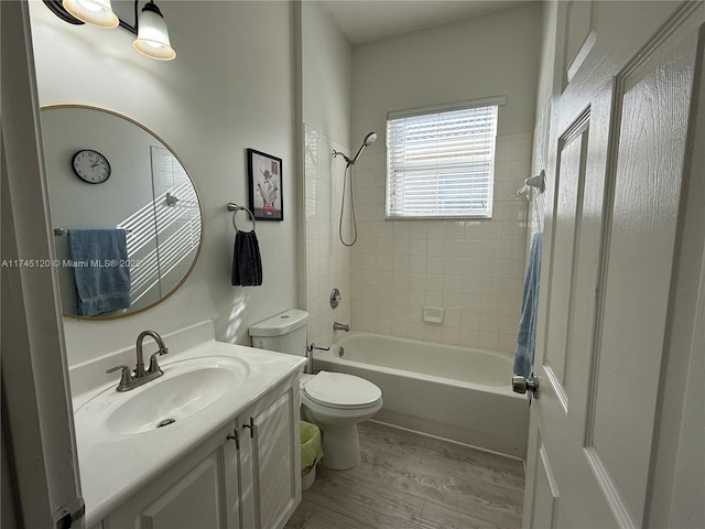 bathroom with vanity,  shower combination, toilet, and wood finished floors