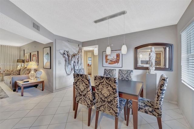 tiled dining space with a textured ceiling