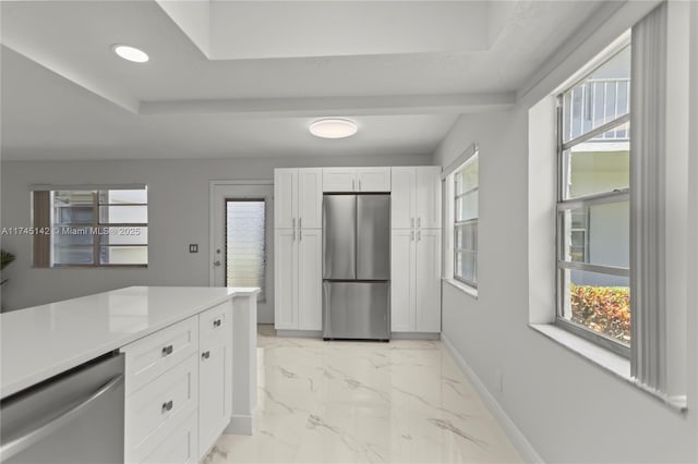 kitchen featuring a raised ceiling, white cabinetry, and appliances with stainless steel finishes