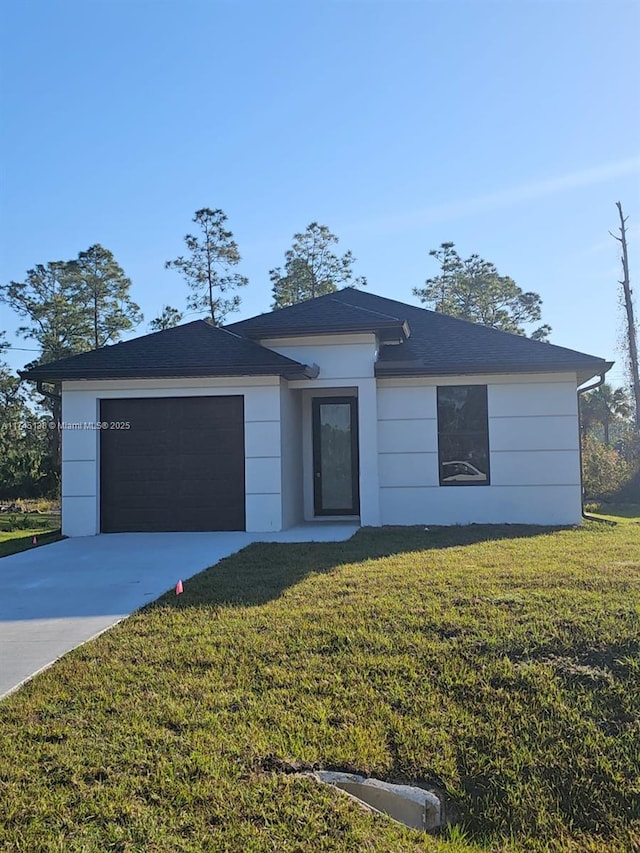 view of front of property with a garage and a front lawn