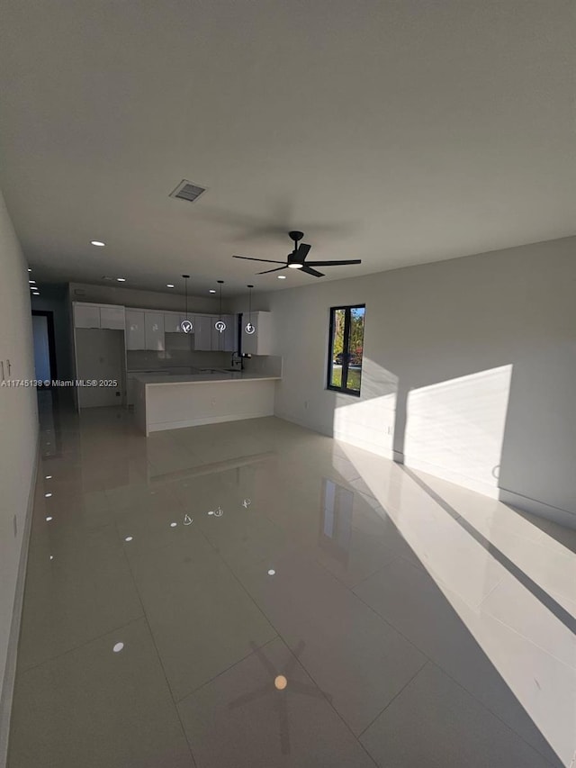 unfurnished living room featuring tile patterned floors and ceiling fan