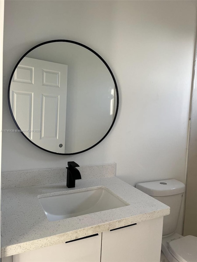 bathroom featuring vanity and toilet