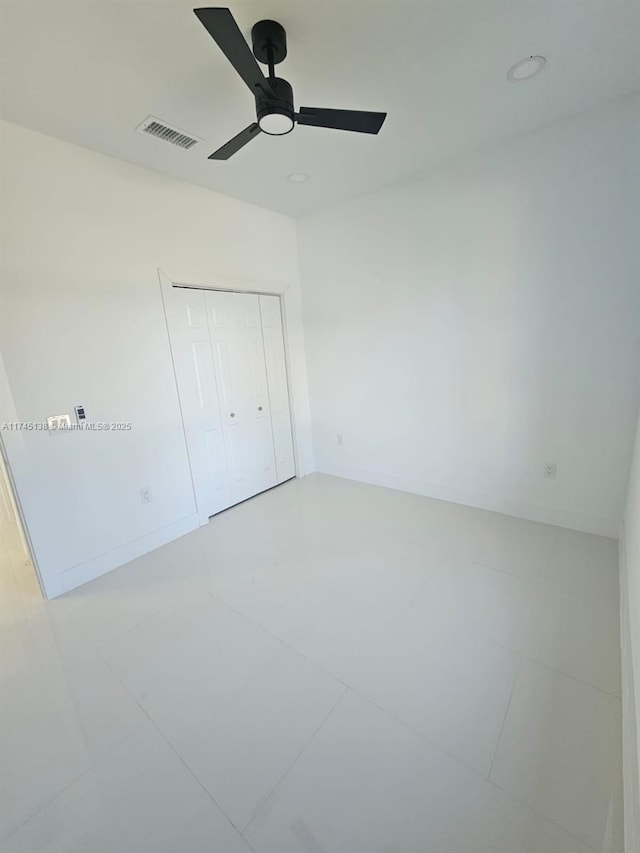 unfurnished bedroom with ceiling fan and a closet