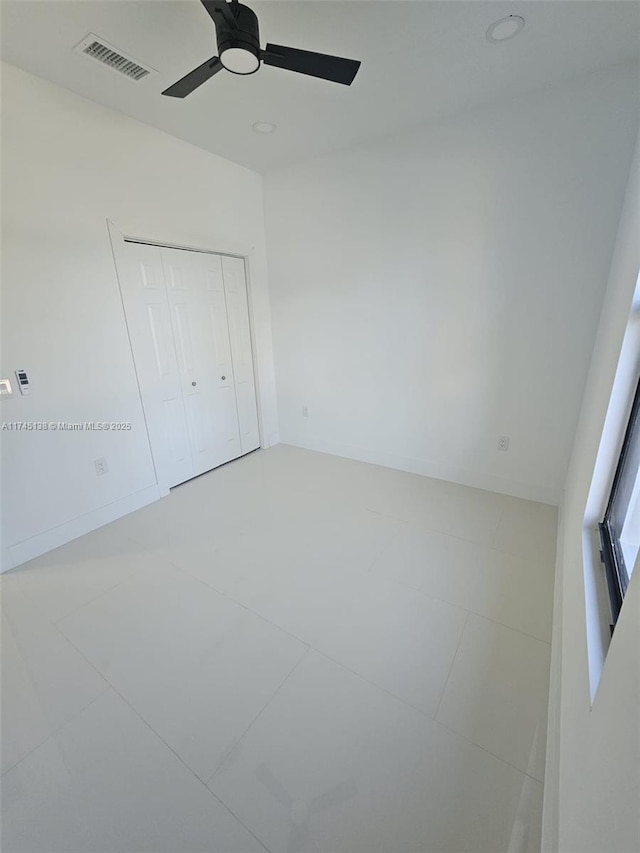 unfurnished bedroom featuring ceiling fan and a closet