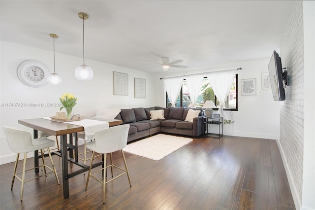 living room featuring ceiling fan, brick wall, and dark hardwood / wood-style flooring