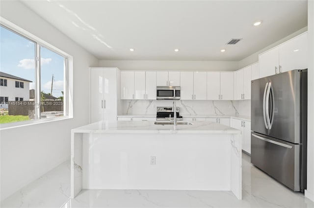 kitchen featuring white cabinetry, sink, light stone countertops, and appliances with stainless steel finishes