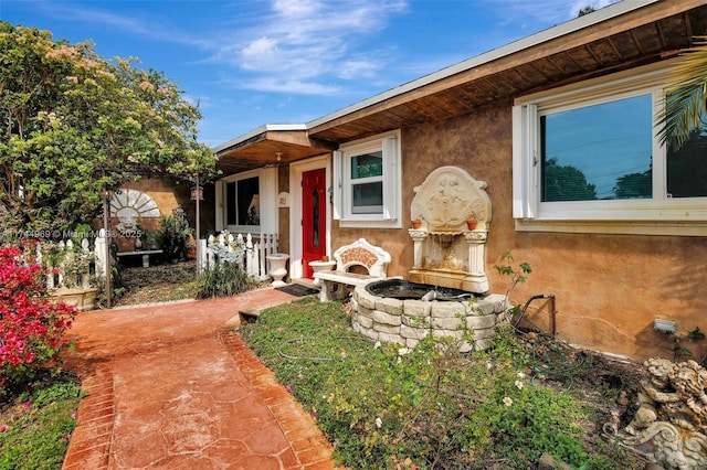 view of front of home with a fire pit and stucco siding