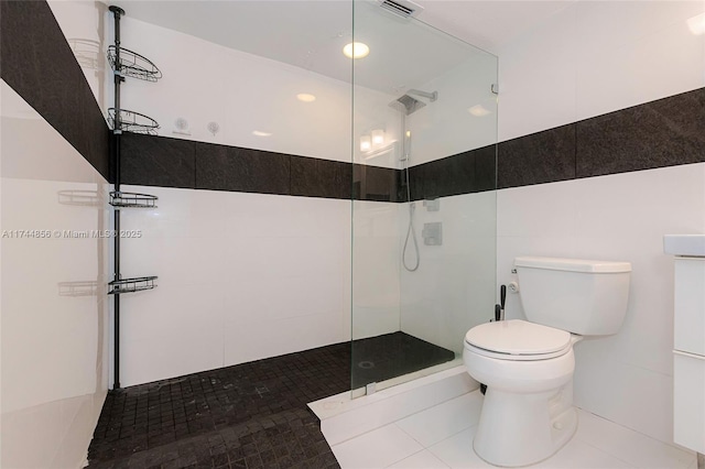 bathroom with toilet and a tile shower