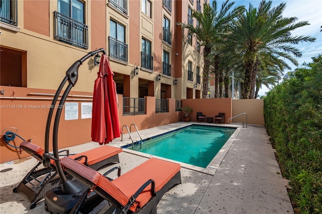 community pool featuring fence and a patio