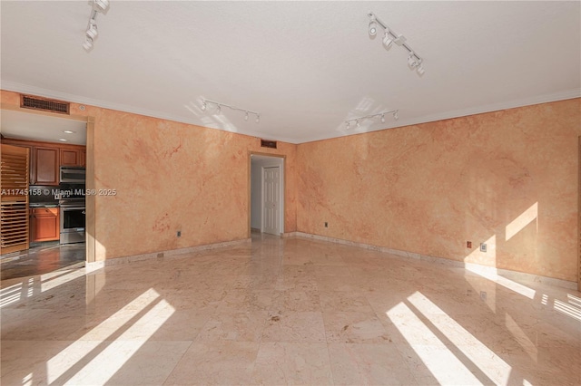 unfurnished room with ornamental molding, visible vents, and track lighting