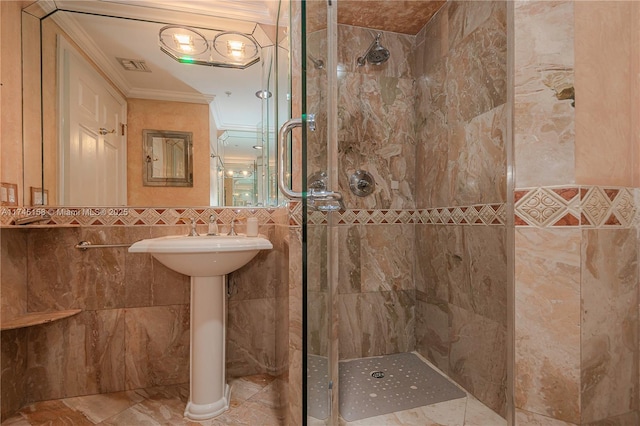 full bath with a shower stall, visible vents, tile walls, and crown molding