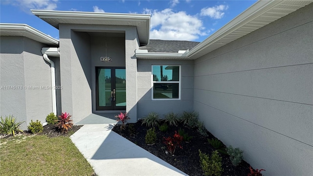 entrance to property with a yard and french doors