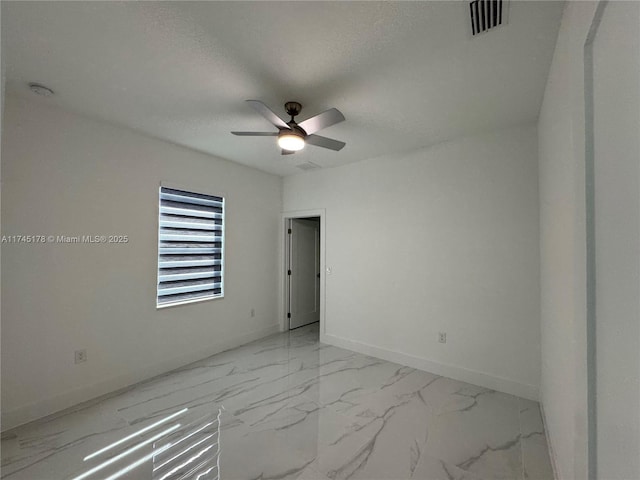 empty room with a textured ceiling and ceiling fan