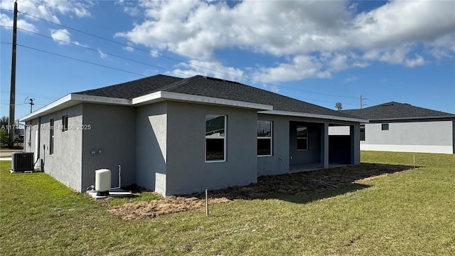 back of property featuring central AC unit and a yard