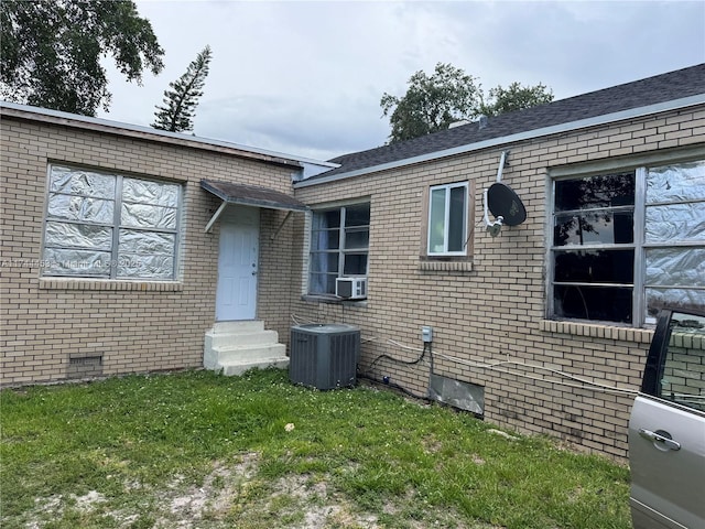 view of front of house featuring central AC unit and a front yard