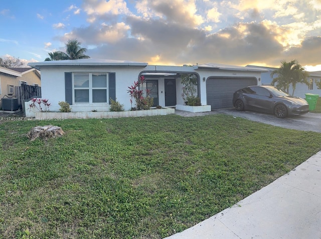 single story home featuring a garage, a yard, and central air condition unit