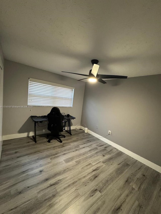 interior space with ceiling fan, hardwood / wood-style floors, and a textured ceiling