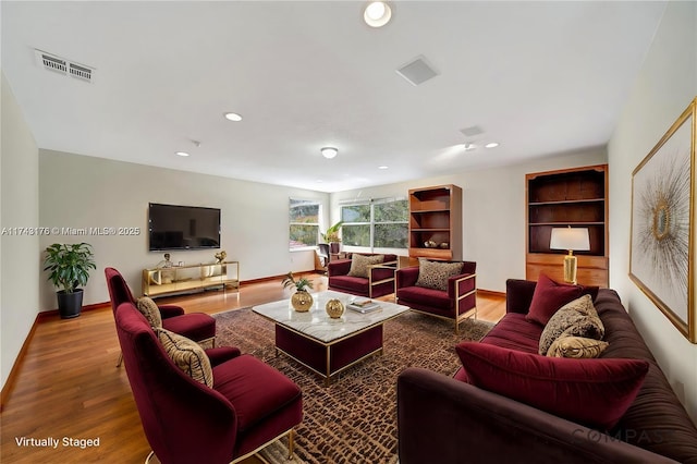 living area with wood finished floors, visible vents, recessed lighting, and baseboards