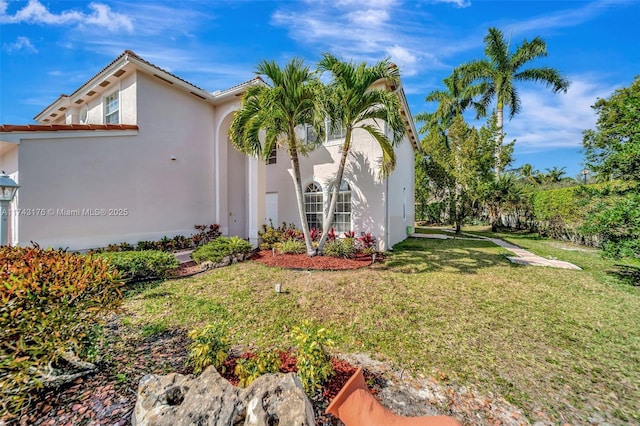 view of front of property featuring stucco siding and a front lawn
