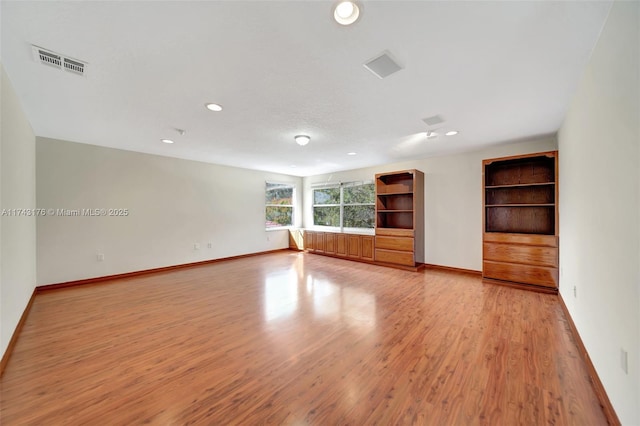 spare room with baseboards, visible vents, light wood-style flooring, and recessed lighting
