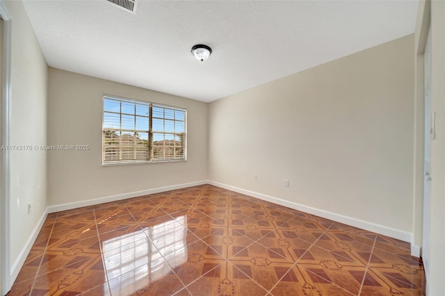 spare room featuring visible vents and baseboards