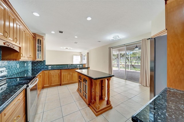 kitchen featuring recessed lighting, glass insert cabinets, stainless steel appliances, a sink, and visible vents