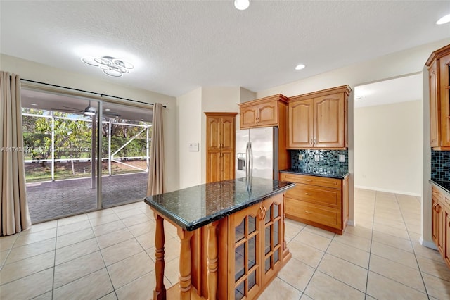 kitchen with light tile patterned flooring, stainless steel refrigerator with ice dispenser, and backsplash