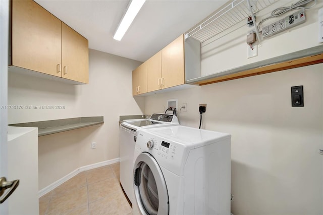 clothes washing area with light tile patterned flooring, cabinet space, independent washer and dryer, and baseboards