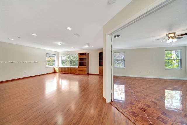 unfurnished living room featuring recessed lighting, a ceiling fan, baseboards, and a healthy amount of sunlight