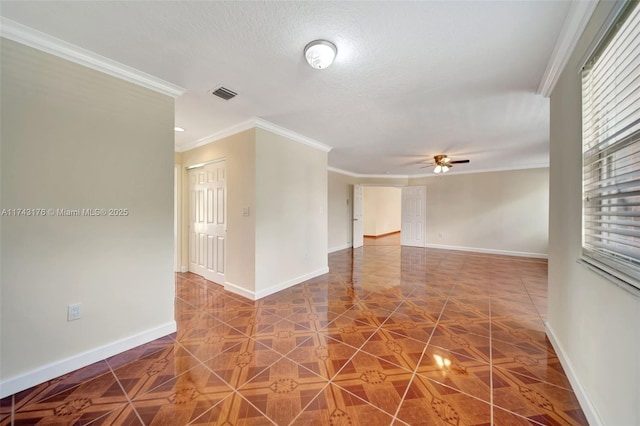 empty room featuring visible vents, a ceiling fan, crown molding, and baseboards