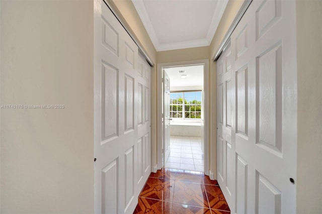 corridor with ornamental molding and dark tile patterned floors