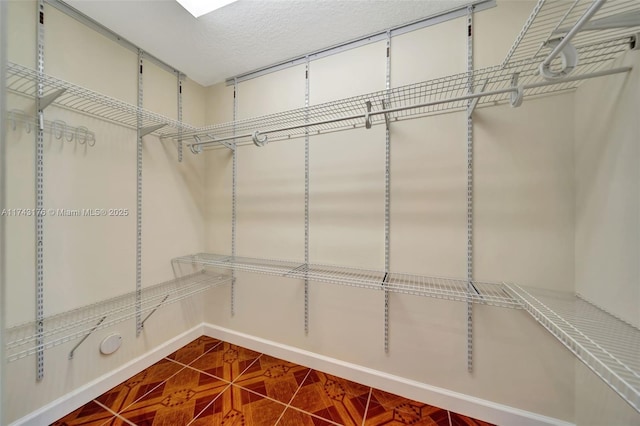 spacious closet with dark tile patterned floors