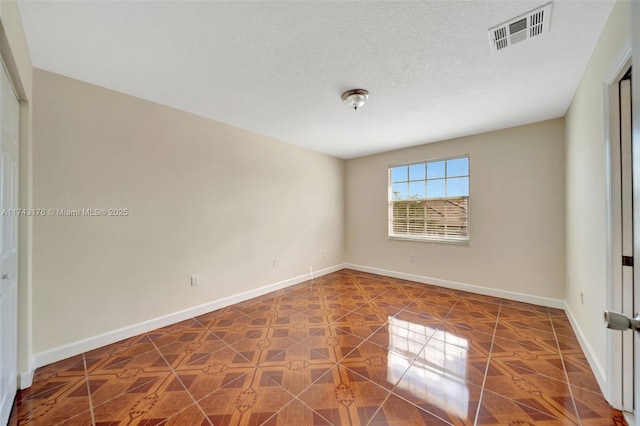 spare room with baseboards and visible vents
