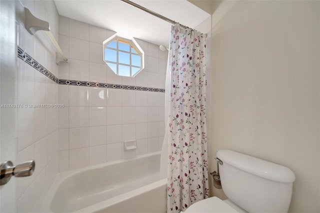 bathroom featuring shower / tub combo and toilet