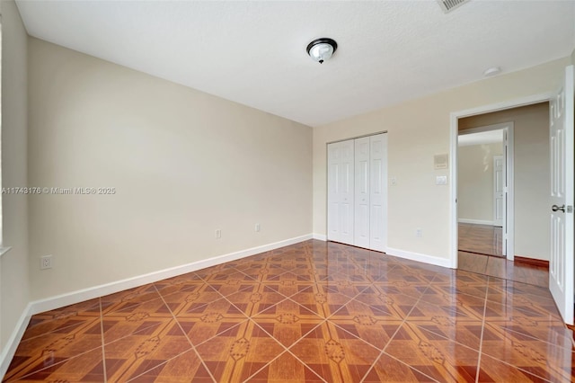 unfurnished bedroom with a closet and baseboards